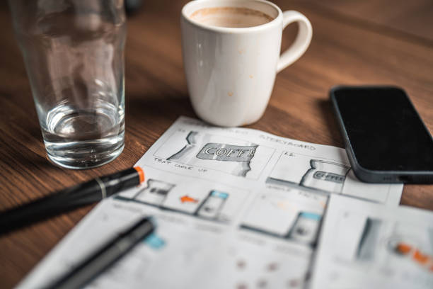 istock Storyboard Editors Table; Coffee, Colored Pencils And A Smartphone 1447408595