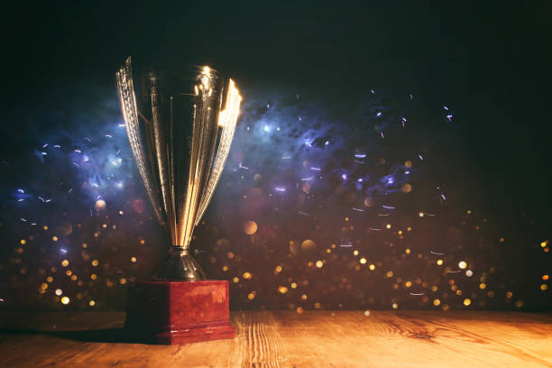 istock image of gold trophy with sparkly overlay over dark background 1447409004