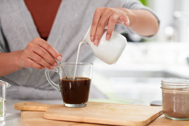 istock Woman Pouring Cream in Coffee 1447410550