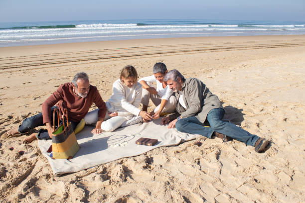 starsi przyjaciele grający razem w domino na świeżym powietrzu - beach couple satisfaction playing zdjęcia i obrazy z banku zdjęć