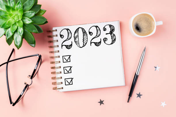 istock New year resolutions 2023 on desk. 2023 resolutions list with notebook, coffee cup on pink background. Goals, resolutions, plan, action, checklist concept. New Year 2023 template 1447412992