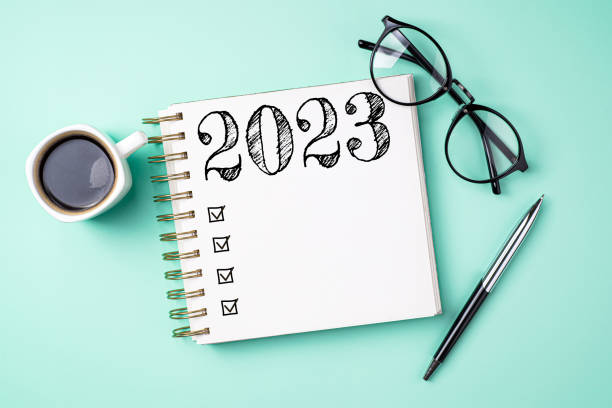 istock New year resolutions 2023 on desk. 2023 resolutions list with notebook, coffee cup on yellow table. Goals, resolutions, plan, action, checklist concept. New Year 2023 template 1447413188