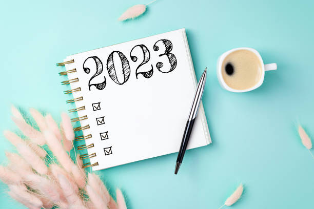 istock New year resolutions 2023 on desk. 2023 resolutions list with notebook, coffee cup on yellow table. Goals, resolutions, plan, action, checklist concept. New Year 2023 template 1447413230