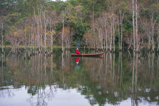 Fisherman in Tuyen Lam lake in a foggy morning, Da Lat city, Lam Dong province, central high lands Vietnam