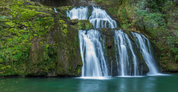 istock Waterfall from the source of the Lison in a haven of peace with its waterfall surrounded by forest. 1447416127