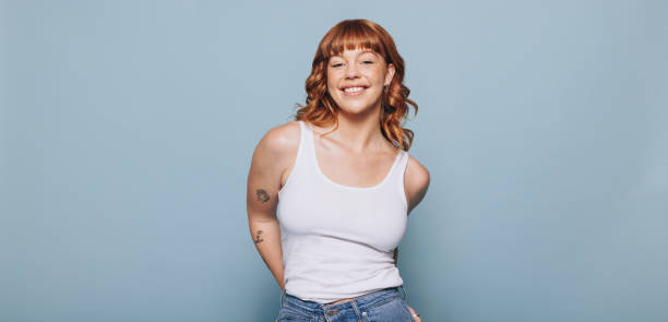 istock Woman with ginger hair standing against a studio background 1447416934