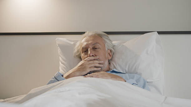 istock Sick elderly man lying in bed, feeling nausea or coughing, suffering from disease 1447417070