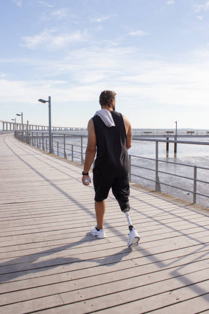 Man with mechanical leg after training on embankment