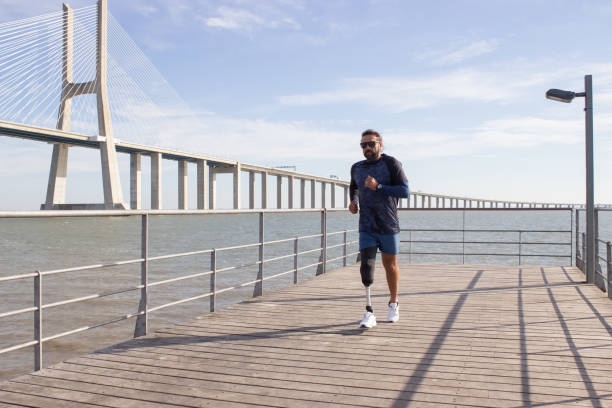 istock Man with mechanical leg running on embankment 1447417951