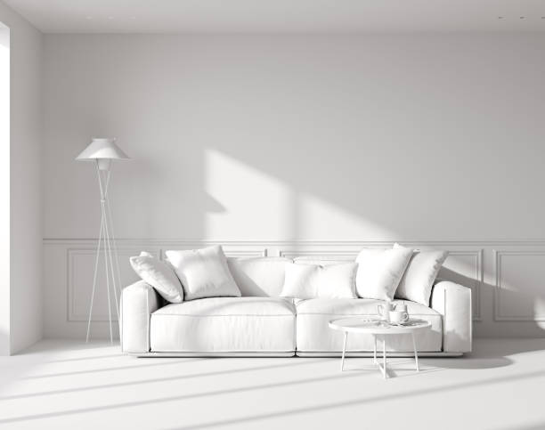 istock White room interior mock up with sunlight shadows and white sofa with coffee table and floor lamp, empty wall mock up, 3d rendering 1447418066