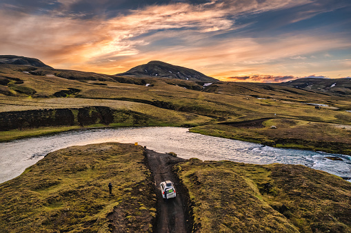 Above of four wheel drive vehicle parked by the big river crossing in the evening on remote rural at Icelandic Highlands