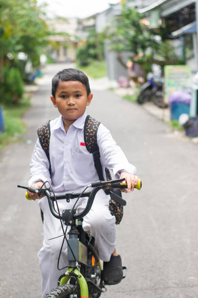 istock Indonesian students in uniform go to school by bicycle 1447423227