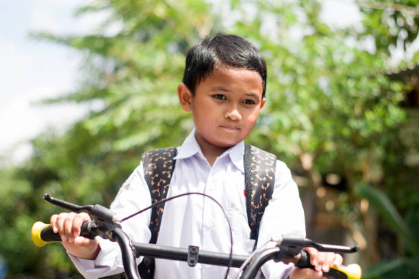 Indonesian students in uniform go to school by bicycle