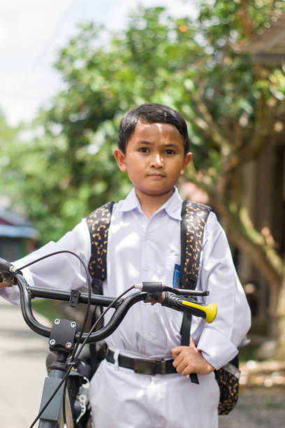 istock Indonesian students in uniform go to school by bicycle 1447425310