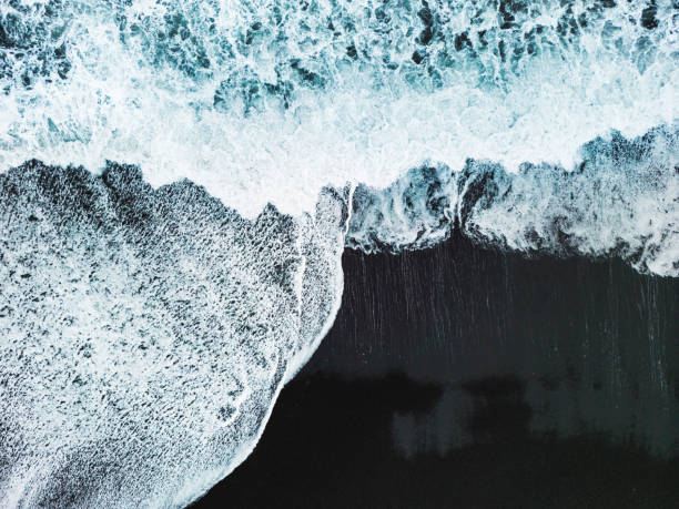 istock Drone shot waves crashing on the black sand beach 1447426697