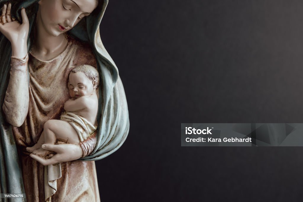 Mary and infant Jesus Statue of the virgin Mary holding the baby Jesus against a black background with copy space Virgin Mary Stock Photo