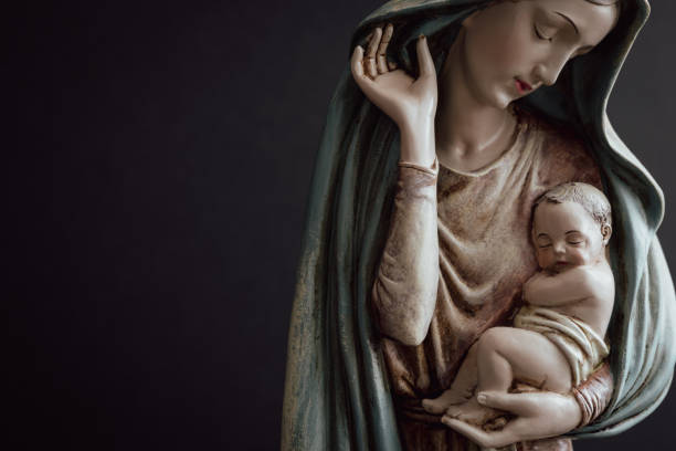 Virgin Mary holding the Child Jesus Statue of the virgin Mary holding the baby Jesus against a black background with copy space virgin-mary stock pictures, royalty-free photos & images