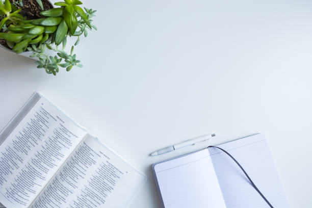 istock Bible, blank journal page, pen and plant 1447427242
