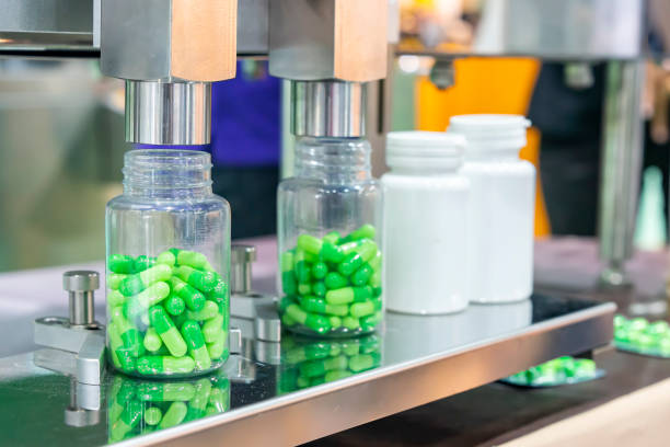 istock close up transparent plastic bottle under nozzle dispenser component of automatic medicine capsule bottle filling and counting machine during manufacturing process 1447427785