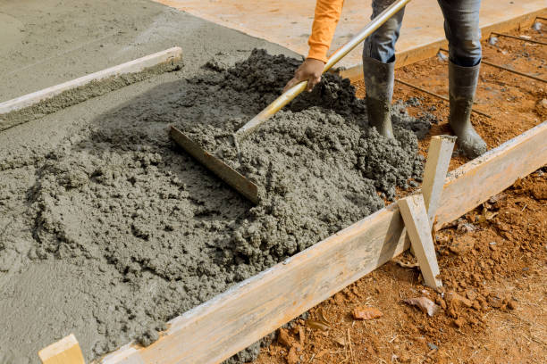 Workers pour cement to create an additional sidewalk to be built on the side of the house by a construction crew Workers pour cement to create an additional sidewalk to be built on side of house by construction crew concrete in formwork stock pictures, royalty-free photos & images
