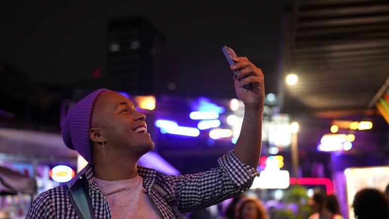 Young man filming outdoors at food truck festival