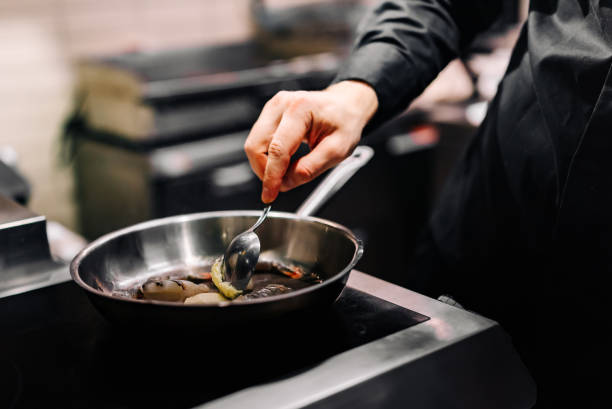istock man chef cooking tasty shrimp in frying pan on kitchen 1447441302