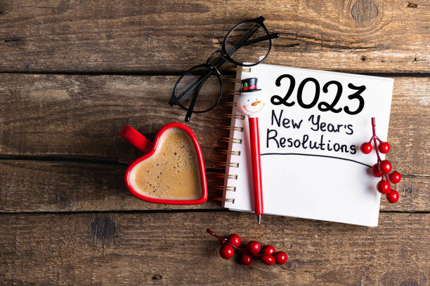 istock New year resolutions 2023 on desk. 2023 resolutions list with notebook, coffee cup, decorations on table. Goals, resolutions, plan, action concept. New Year 2023 background 1447443171