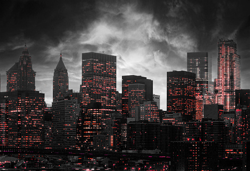 Red lights shining from the buildings of a black and white New York City skyline at night with dark clouds swirling above