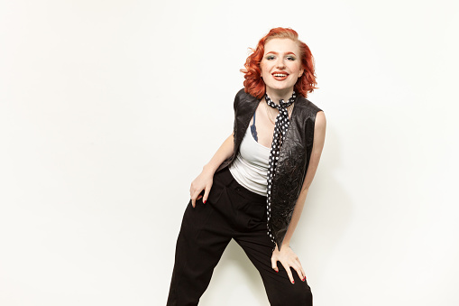 Studio portrait of a young red-haired white woman dressed in retro style against a white background