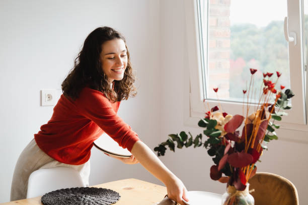 istock Young happy woman setting the table at home 1447447891