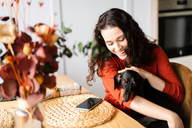 istock Happy young woman caressing her dachshund dog 1447447902