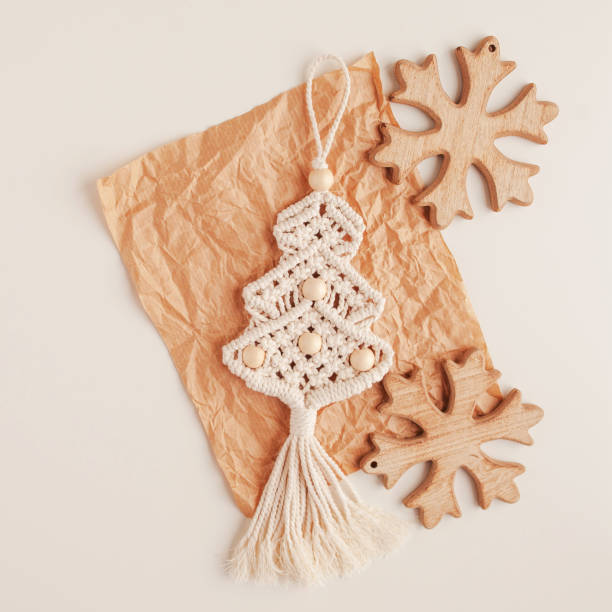 christmas tree macrame toys on craft papper. white background. natural materials - cotton thread, wood beads and stick. eco decorations, ornaments, hand made decor. winter and new year holidays. - christmas tree bead humor imagens e fotografias de stock