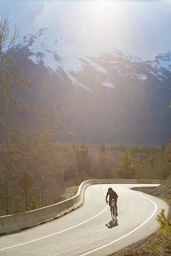 A woman goes for a road bicycle ride along the HIghway 1A or Bow Valley Parkway in Banff National Park west of Banff, Alberta, Canada. Portions of the Bow Valley Parkway are closed to motor vehicle traffic during some periods of time in the spring and summer months and are open only for bicycles and pedestrians.