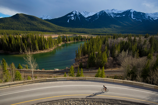 A woman goes for a road bicycle ride along the HIghway 1A or Bow Valley Parkway in Banff National Park west of Banff, Alberta, Canada.  Portions of the Bow Valley Parkway are closed to motor vehicle traffic during some periods of time in the spring and summer months and are open only for bicycles and pedestrians.