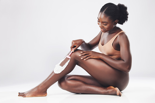 Grooming, shaving cream and black woman model busy with body hygiene and skin cleaning. Beauty, cosmetic and wellness of a person from Kenya with a legs shave and care razor with lotion and soap