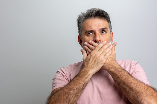 Portrait Of Shocked Man Covering Mouth