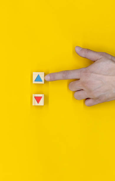 istock The hand that selects down among the wooden blocks marked with the up and down icon 1447454419