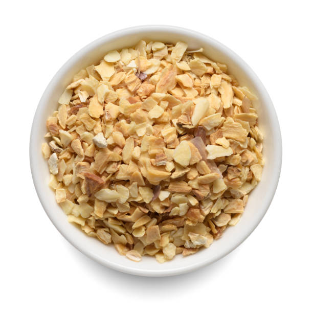 istock Dried garlic granules in white bowl isolated on white. Top view. 1447454572