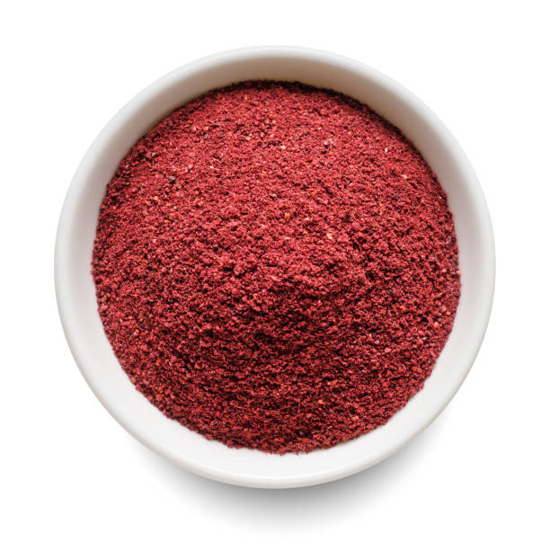 istock Dry ground sumac in white bowl isolated on white. Top view. 1447454582