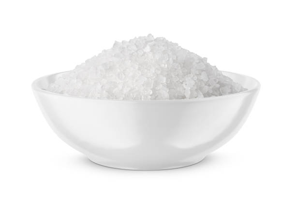 istock Coarse sea salt in white bowl isolated on white. Front view. 1447454601