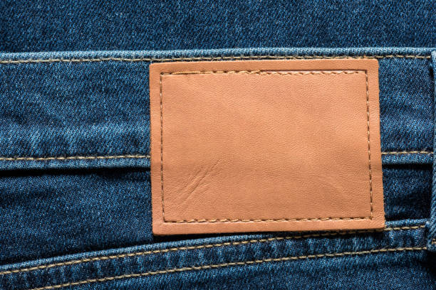 istock Orange leather label on blue jeans with copy space for your text. 1447454671