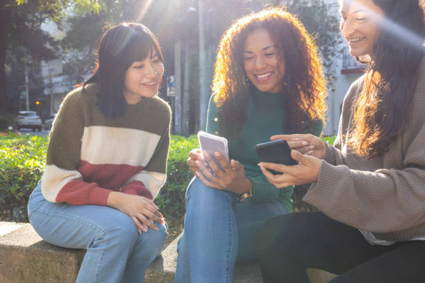 istock Friends sitting and using mobile phone 1447457774