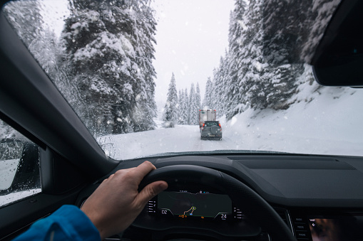 Unrecignisable male driving in a blizzard
