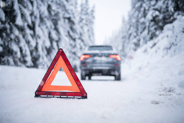 istock Jeep stuck on a snowy road, protected by a hazard sign. 1447458252