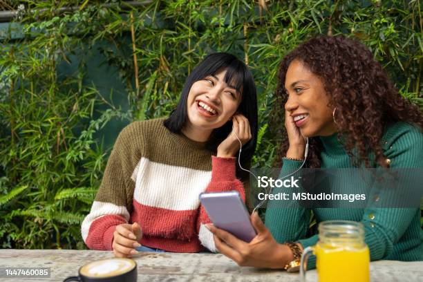 Two Women Looking At Funny Videos On The Mobile Phone Stock Photo - Download  Image Now - iStock