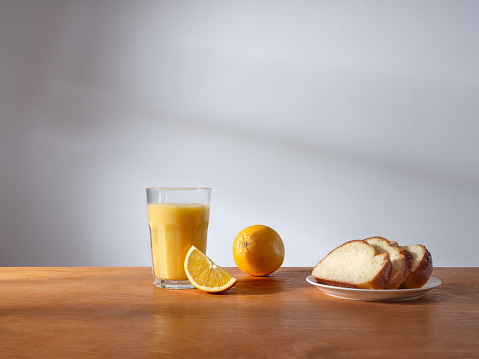 Breakfast with a glass of fresh-pressed orange juice and some slices of brioche bread