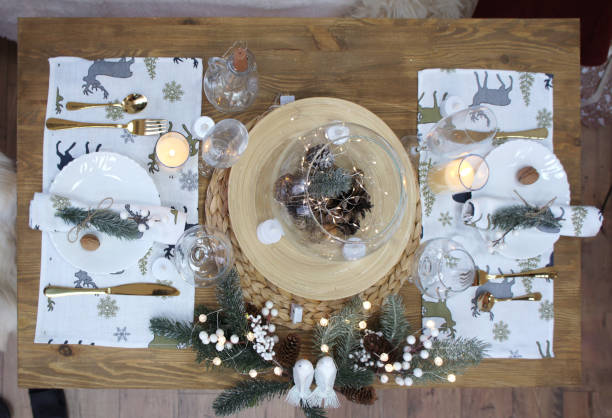 istock Festive New Year's table setting with Christmas decor. Romantic dinner for two people. plates, cutlery, glass vase with pine cones, fir branches, wine glasses, napkins and candles. Top view. 1447461732