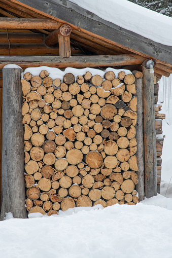 Logs stacked tightly for storage and protection from wind and cold weather in Montana, USA.