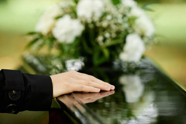 Close up of female hand on coffin Close up of female hand on coffin saying goodbye at outdoor funeral ceremony, copy space death stock pictures, royalty-free photos & images