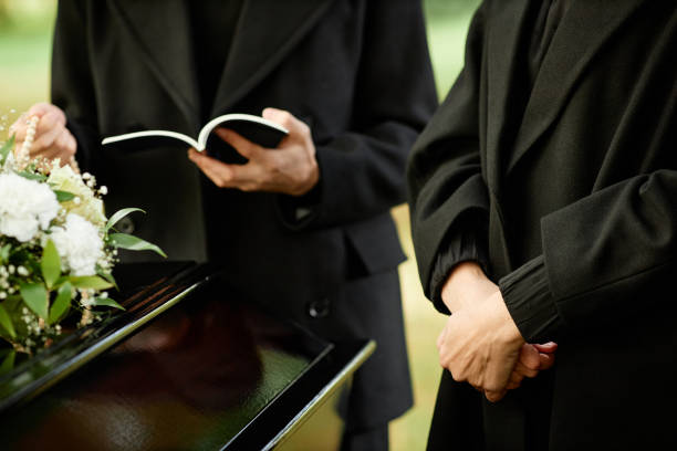 istock Outdoor funeral ceremony with priest reading prayer 1447462447